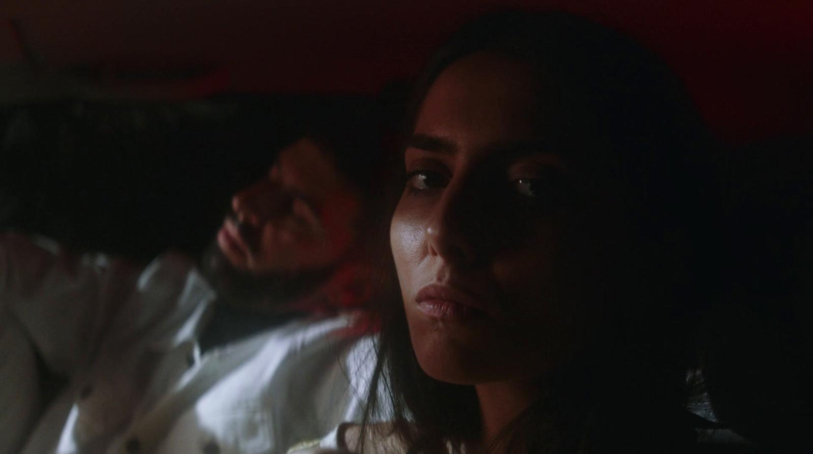 a man and a woman sitting in the back of a car