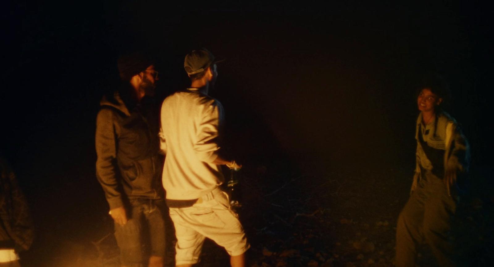 a group of young men standing around a fire