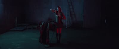 a woman standing in a dark room holding a frisbee