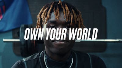 a man with dreadlocks standing in front of a bar