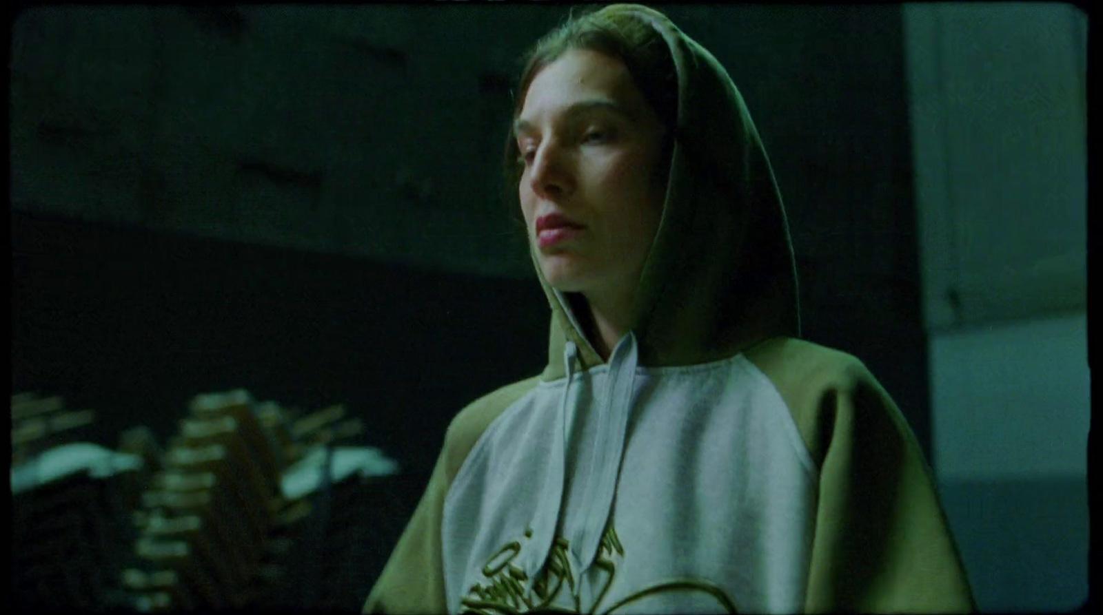 a woman wearing a hoodie in a dark room