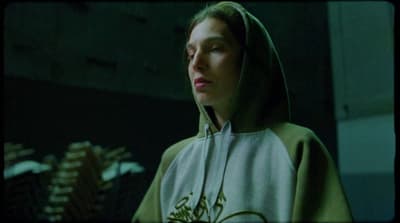 a woman wearing a hoodie in a dark room