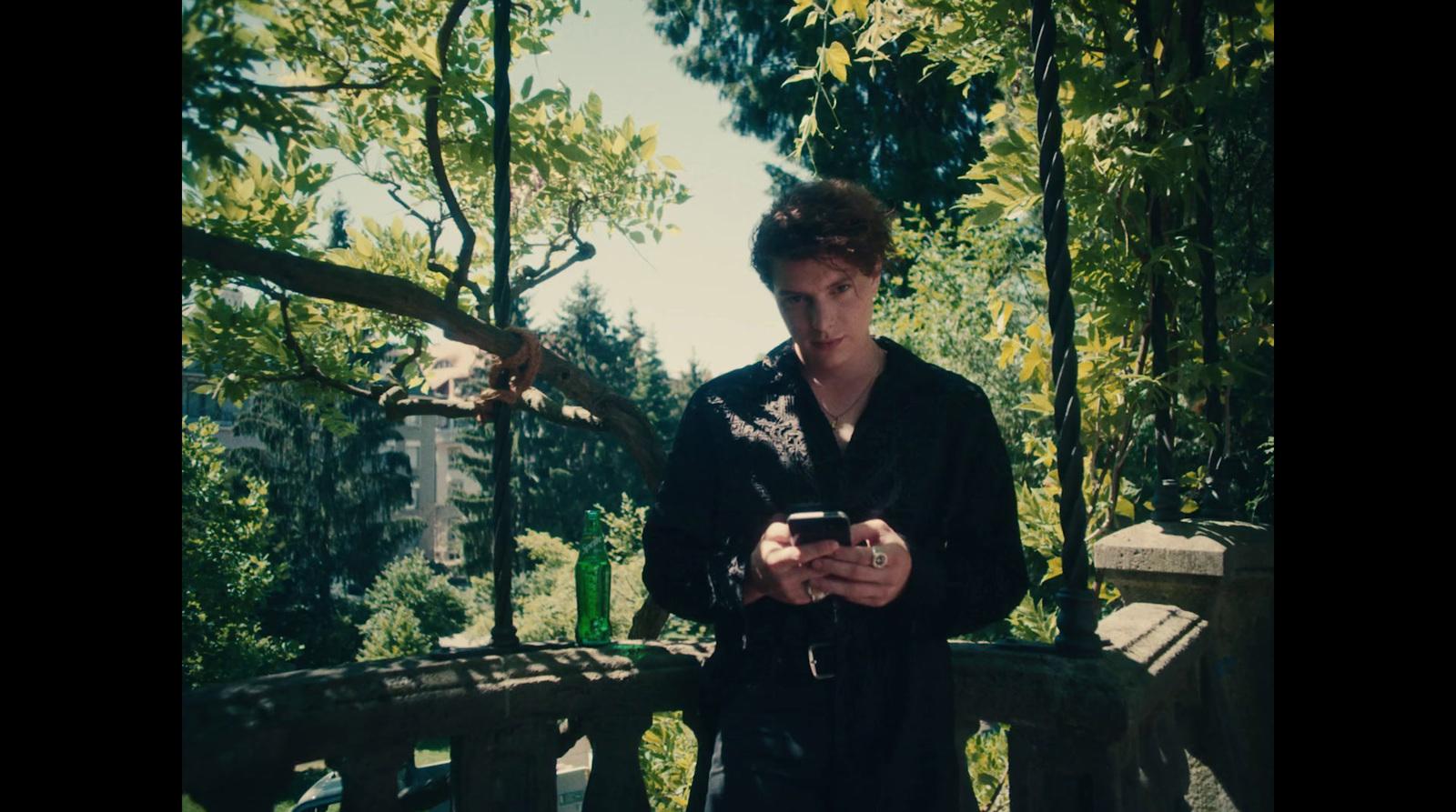 a man standing on a bridge looking at his cell phone