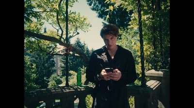 a man standing on a bridge looking at his cell phone