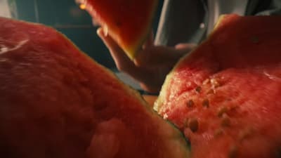 a close up of a person cutting a piece of watermelon