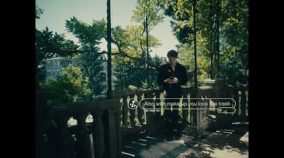 a man is standing on a bridge looking at his cell phone