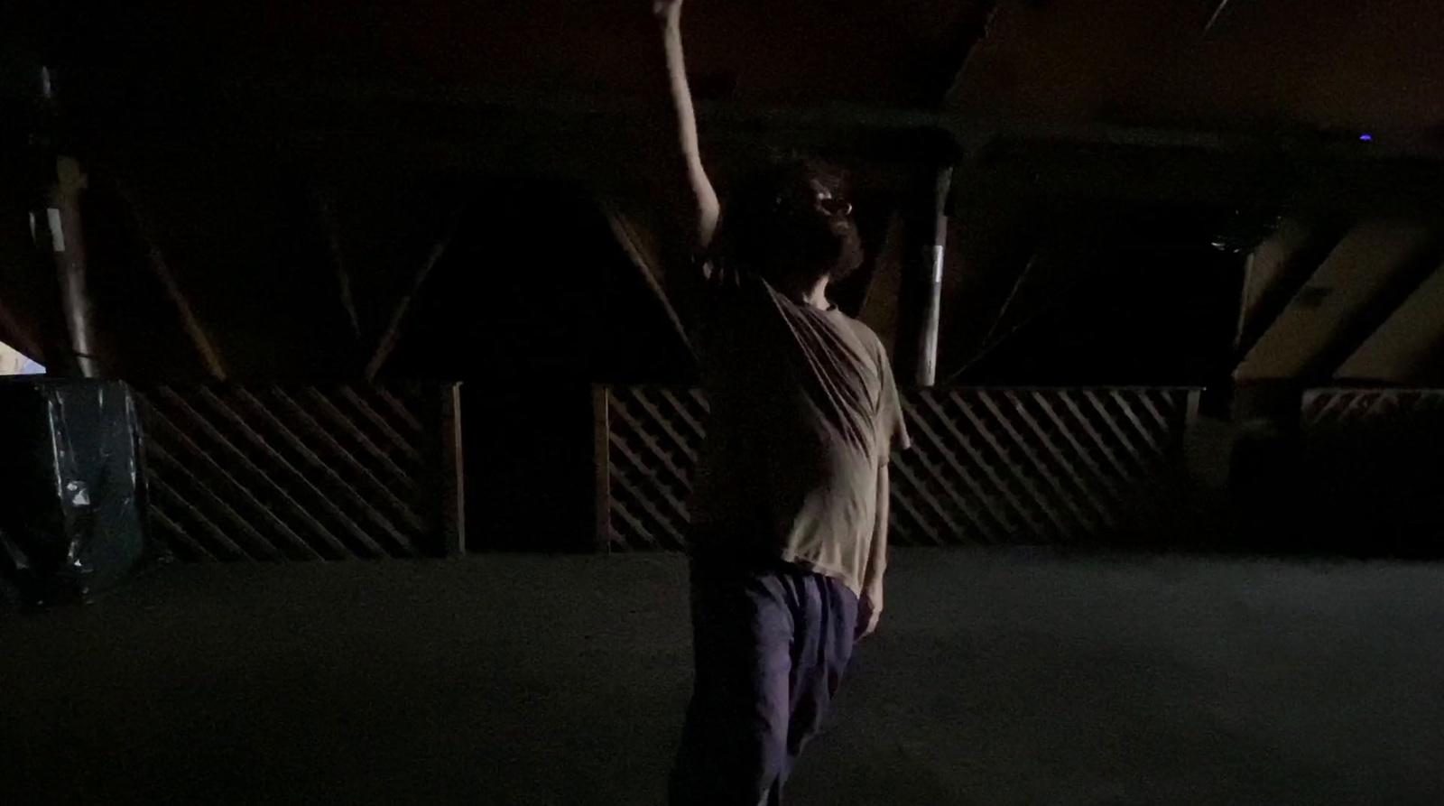 a man standing in the dark holding a frisbee