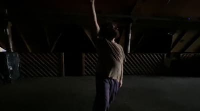 a man standing in the dark holding a frisbee