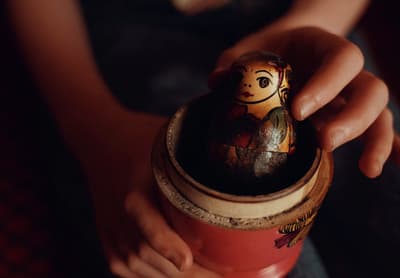 a person holding a small wooden doll in their hand