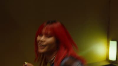 a woman with red hair holding a cell phone