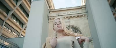 a woman standing in front of a tall building