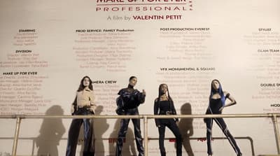a group of women standing next to each other in front of a wall