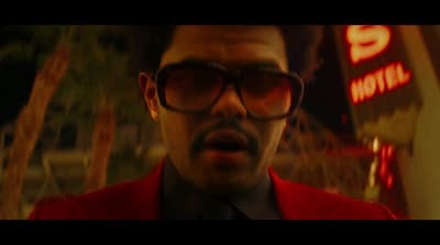 a man in a red jacket and sunglasses making a face