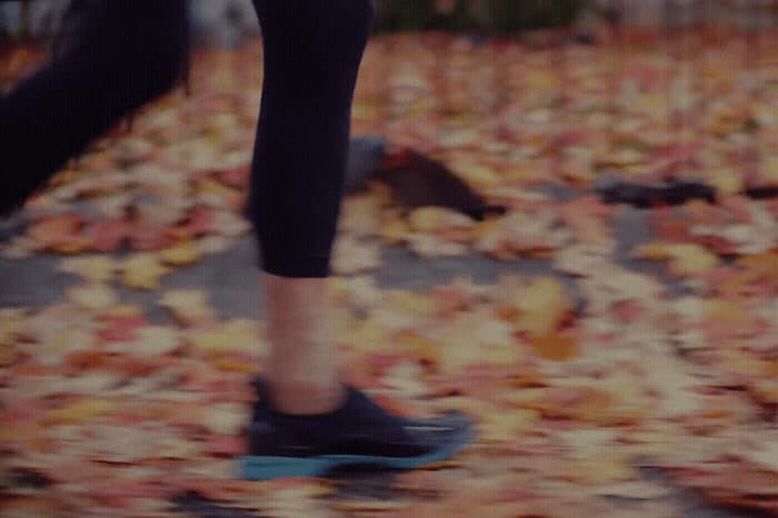 a person riding a skateboard on a leaf covered ground