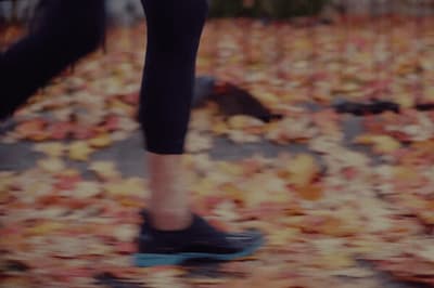 a person riding a skateboard on a leaf covered ground