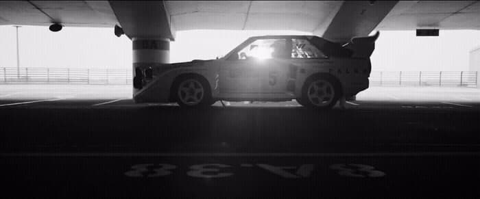 a car parked in a parking garage under a bridge