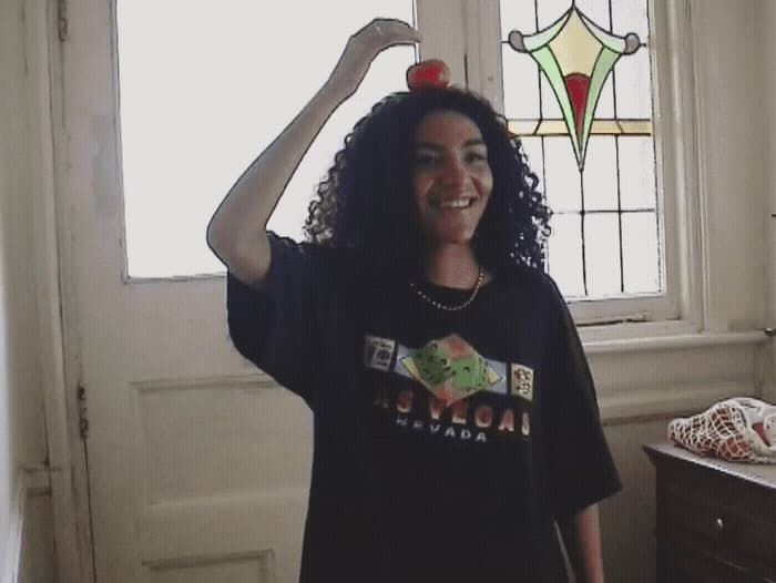 a woman standing in front of a window with an apple on her head