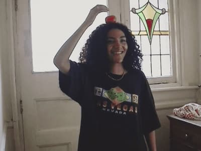 a woman standing in front of a window with an apple on her head