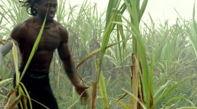 a man walking through a field of tall grass