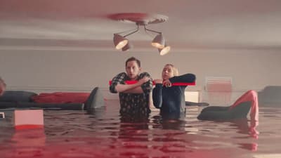 a couple of people standing in a flooded room