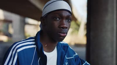 a man in a blue jacket and a white hat