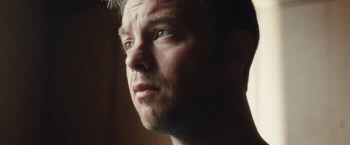 a man is staring into the distance with a serious look on his face