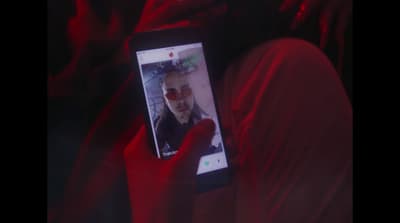 a person holding a cell phone up to their face