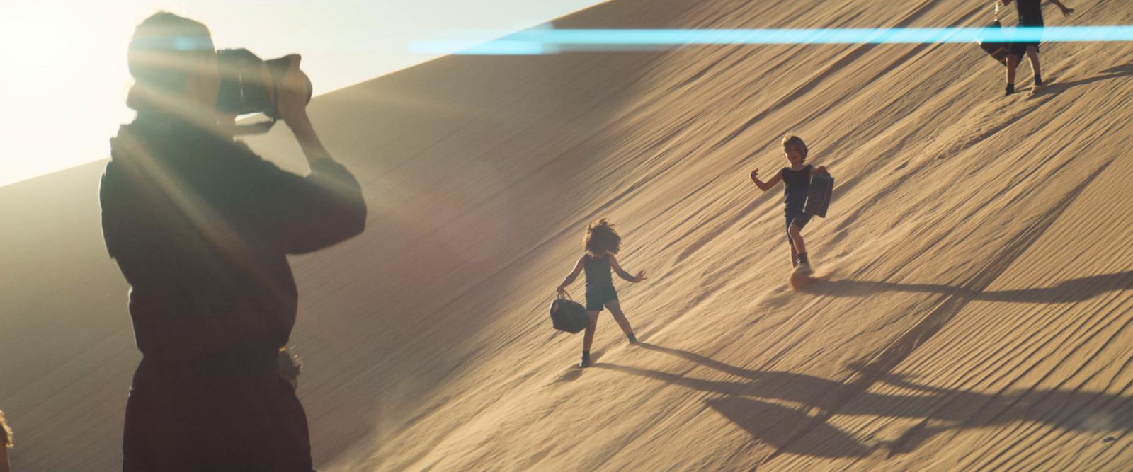 a group of people standing on top of a sandy hill
