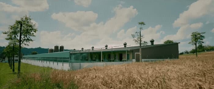 a large building sitting on top of a lush green field
