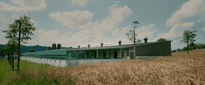 a large building sitting on top of a lush green field