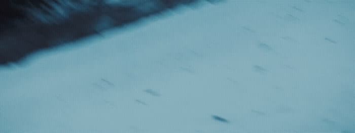 a blurry photo of a snowboarder going down a hill