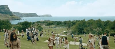 a large group of people walking on a grassy field