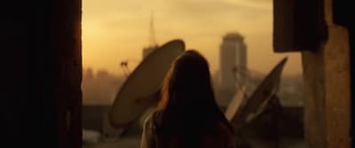 a woman looking out a window at a city
