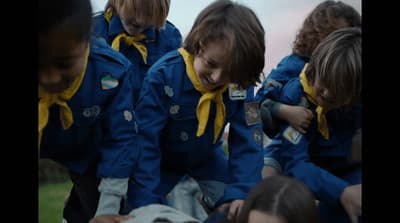 a group of young children wearing blue and yellow jackets