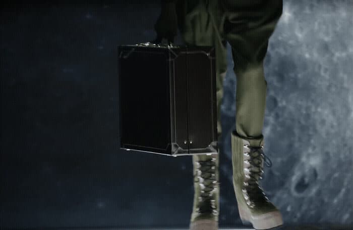 a person holding a piece of luggage in their hand