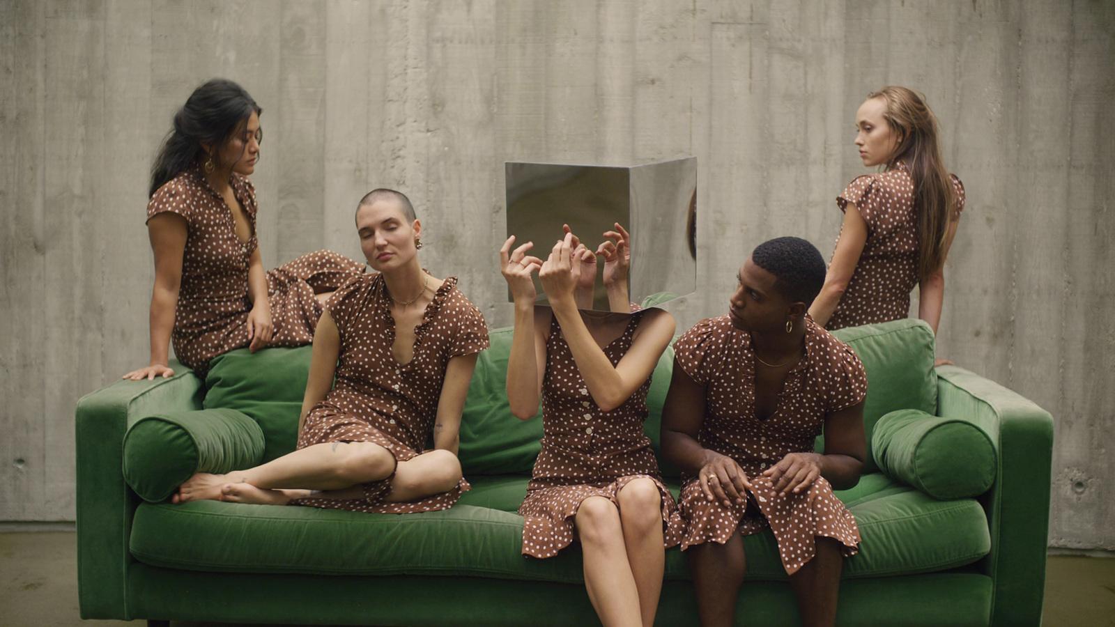 a group of women sitting on top of a green couch