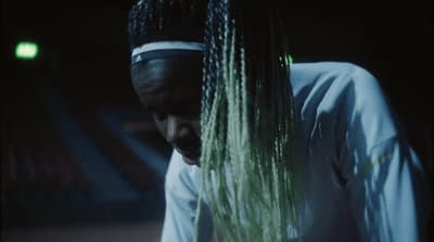 a man with dreadlocks looking down at his cell phone