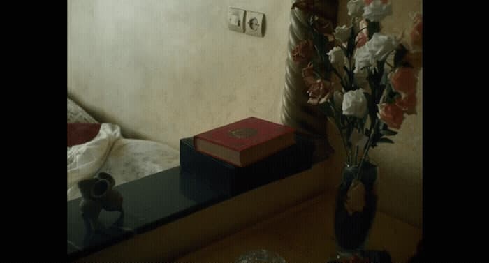 a vase of flowers sitting on a table next to a mirror