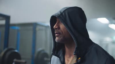 a man with a hoodie on in a gym