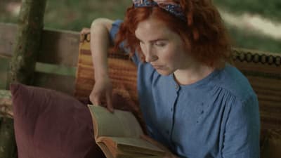 a woman sitting on a bench reading a book