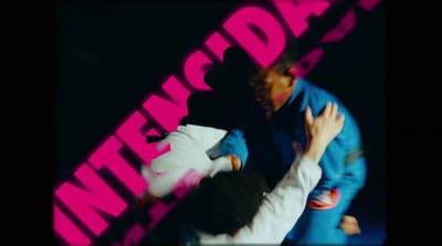 a man and a woman dancing in front of a pink sign