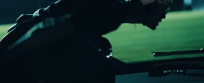 a man in a black jacket leaning on a motorcycle
