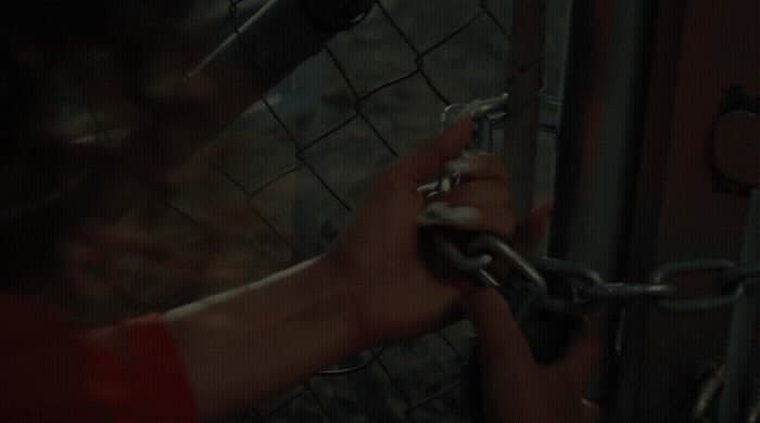 a person is holding a chain on a fence