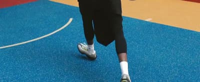 a woman is running on a basketball court