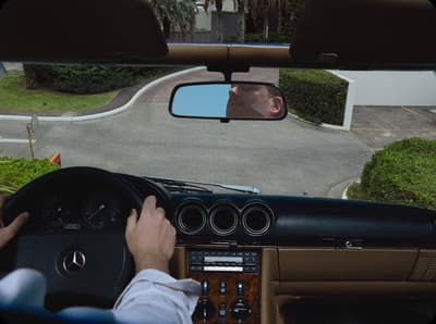 a man driving a car down a street