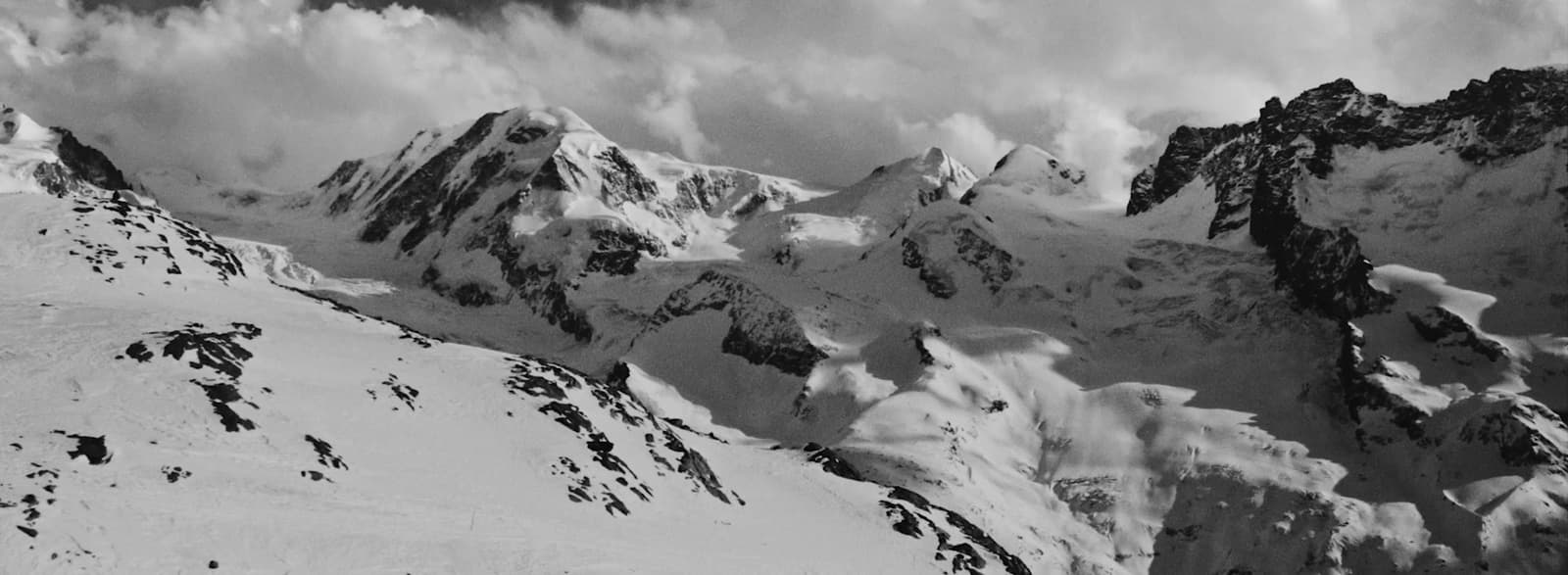 a black and white photo of snow covered mountains