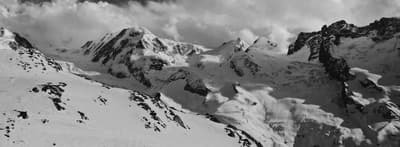 a black and white photo of snow covered mountains