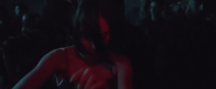 a woman in a red dress standing in a dark room