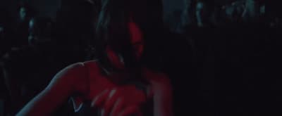a woman in a red dress standing in a dark room