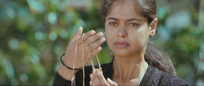 a woman holding a necklace in her hands